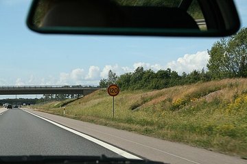 Загородное шоссе, у обочины знак ограничения скорости
