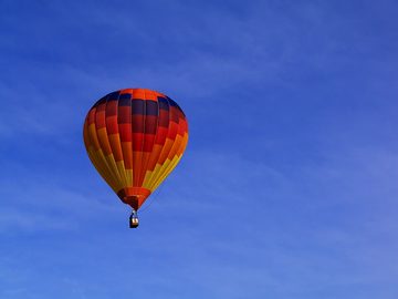 Красно-оранжевый воздушный шар в голубом небе